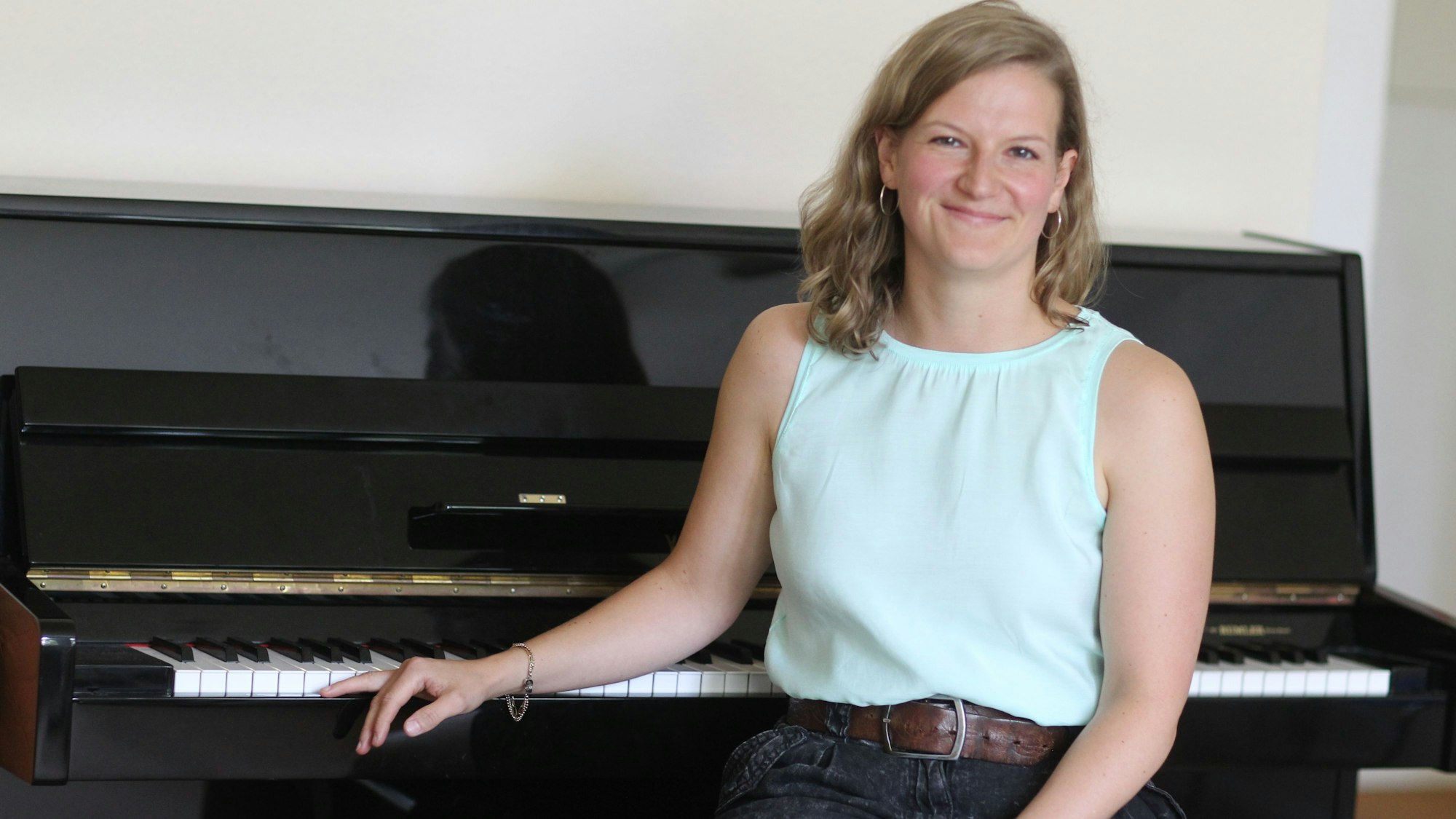 Eine Frau sitzt vor einem Klavier.