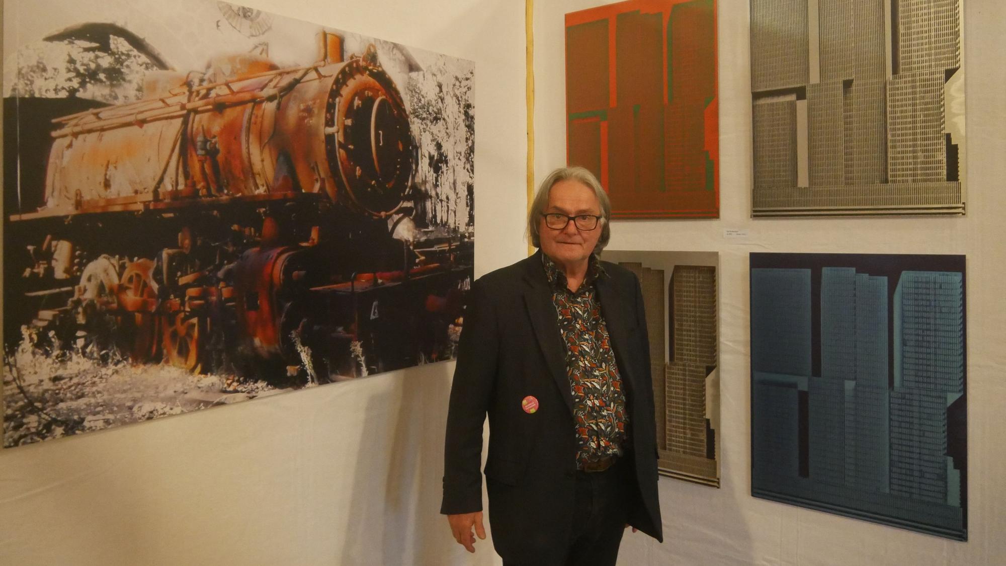 Ein Mann vor Bildern in einer Ausstellung