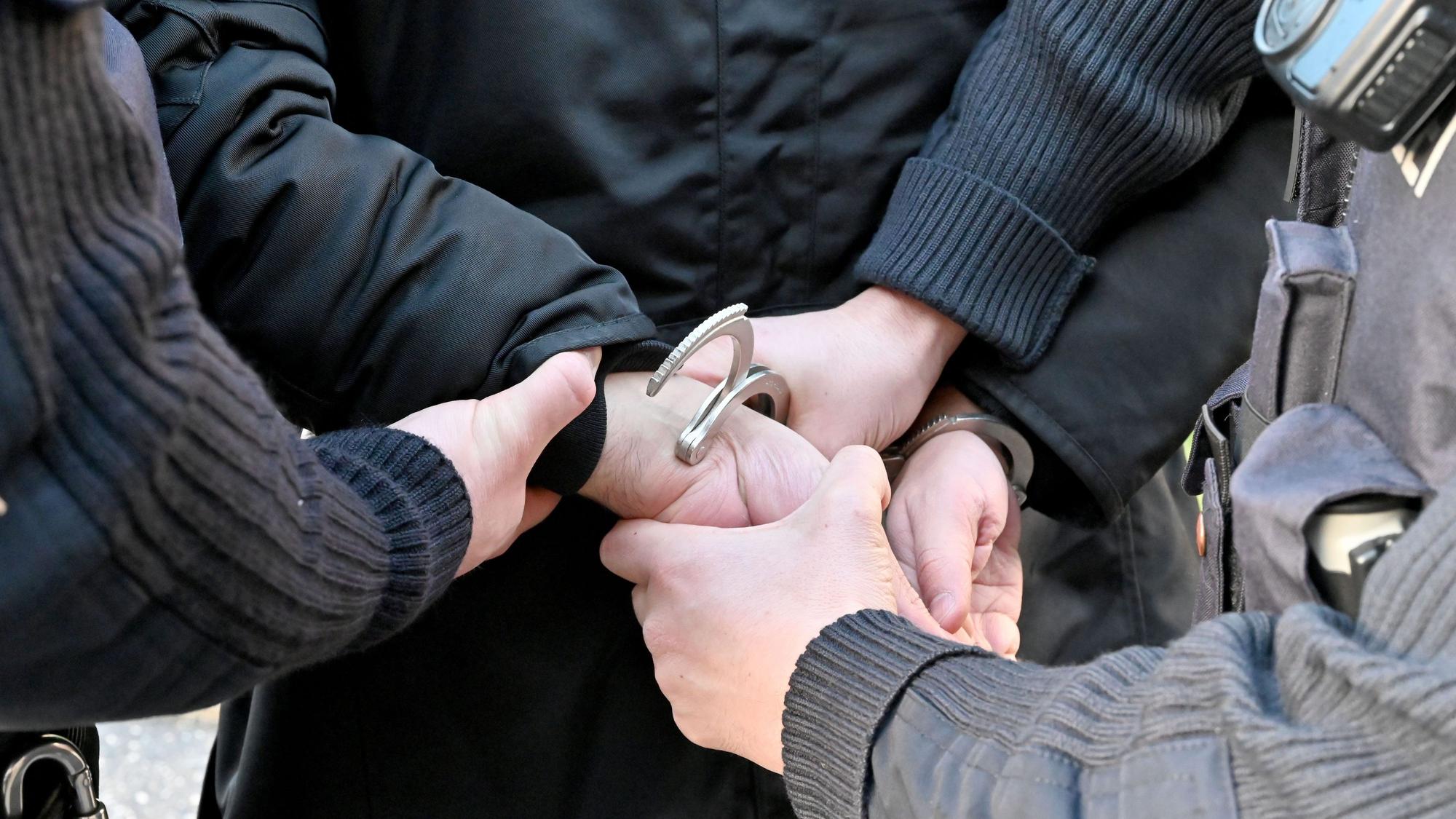 Festnahme durch die Polizei, Handschellen und Hände sind zu sehen.