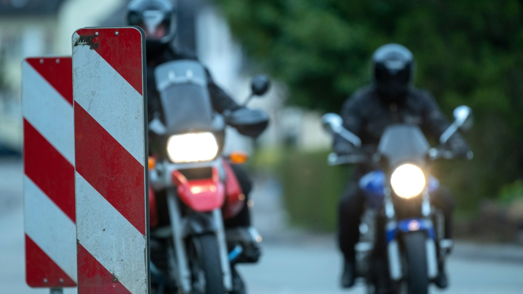 Zwei Motorradfahrer fahren an Warnbaken vorbei (Symbolfoto).