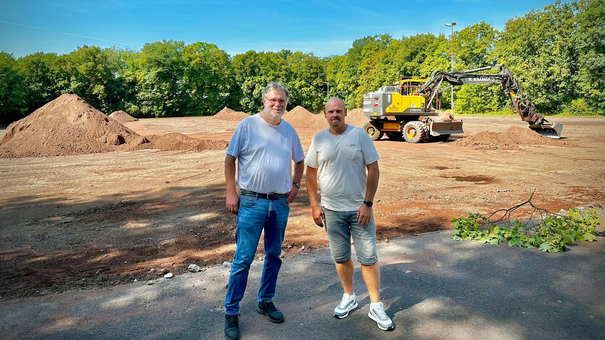 Präsident Hans-Georg Offermann (l.) und Abteilungsleiter Mario Petrovic stehen am Dienstag (27. August 2024) vor dem Sportplatz des RSV Rath-Heumar, der derzeit zum Kunstrasenplatz umgebaut wird.