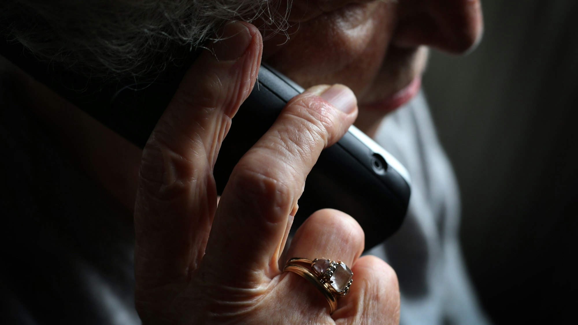Eine ältere Frau telefoniert mit einem schnurlosen Festnetztelefon.