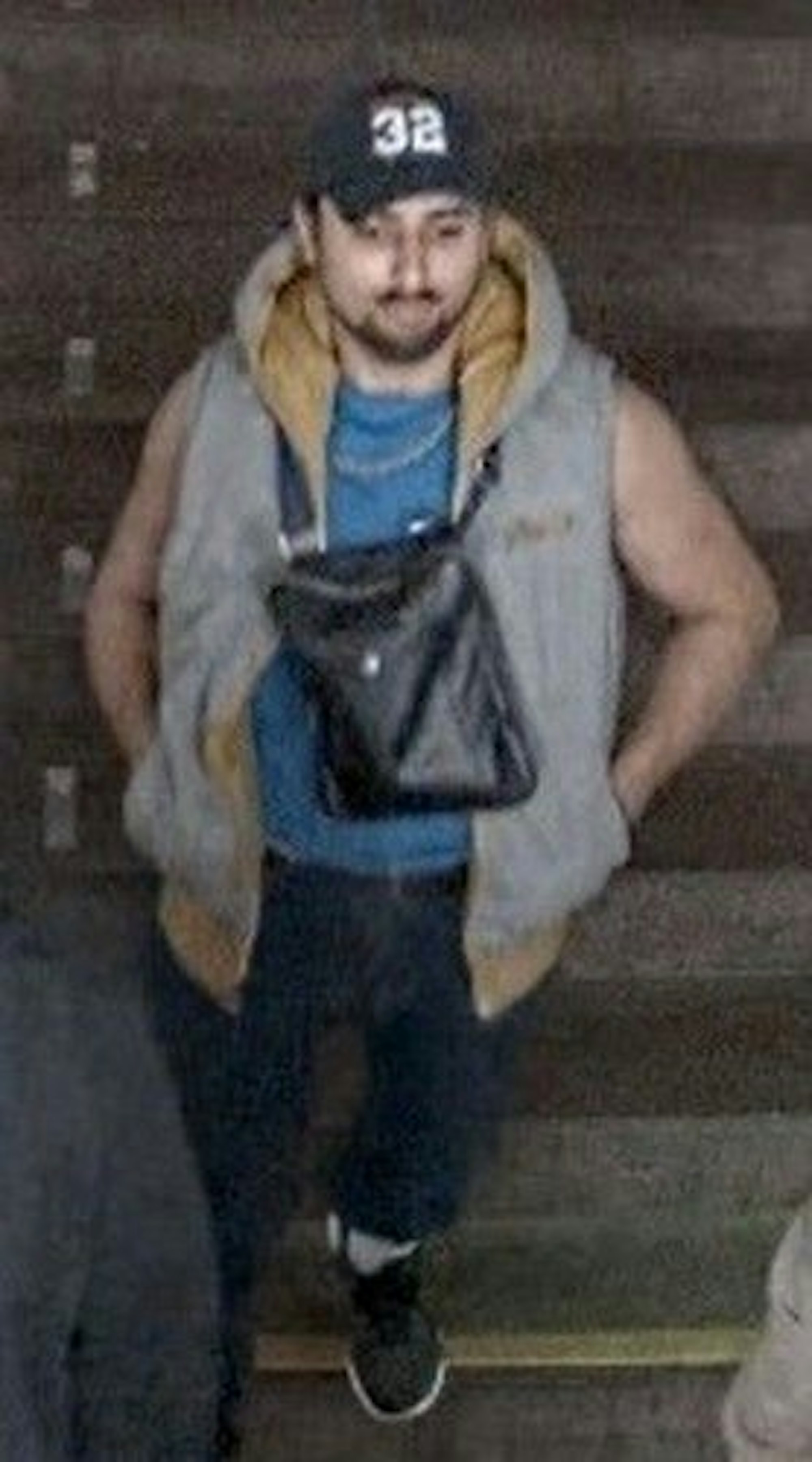 Ein Mann mit Kappe, Umhängetasche und Weste.