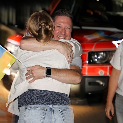 Menschen umarmen sich in der Nacht an der Gesamtschule in Bergisch Gladbach-Paffrath.