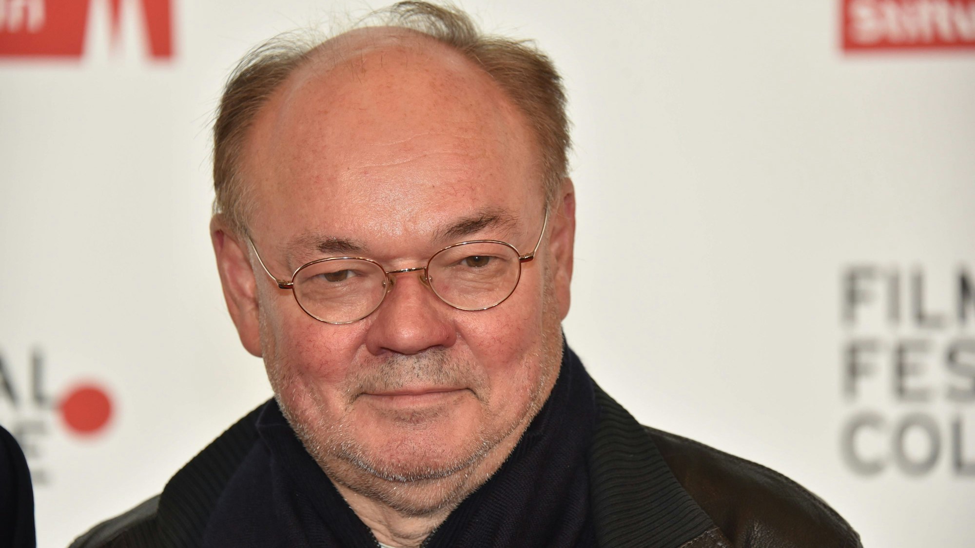 Der Journalist Lutz Hachmeister steht vor einer weißen Wand. Er trägt eine schwarze Jacke