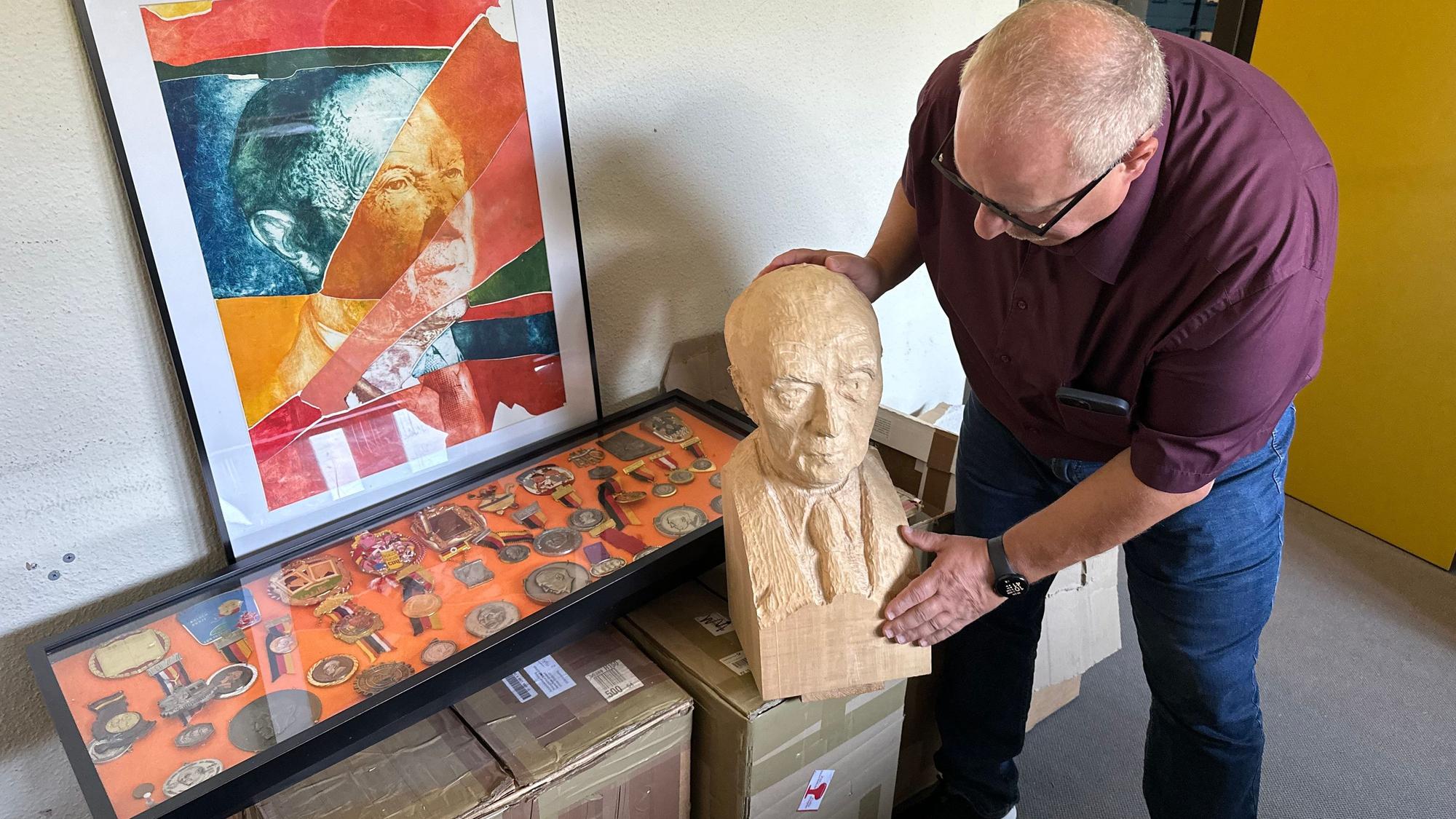 Michael Hansmann, Leiter Schriftgutarchiv, hält eine Büste von Konrad Adenauer in der Hand.