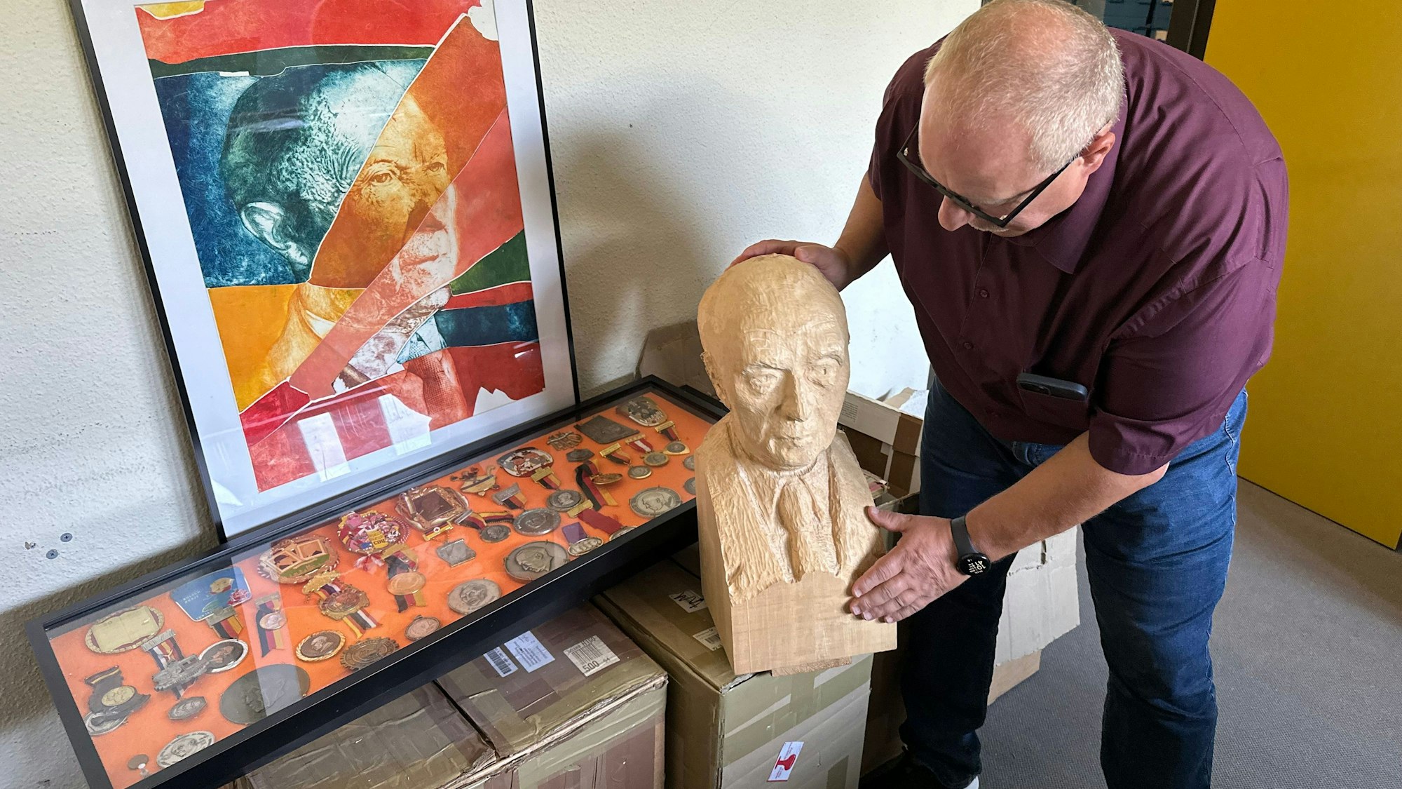 Michael Hansmann, Leiter Schriftgutarchiv, hält eine Büste von Konrad Adenauer in der Hand.