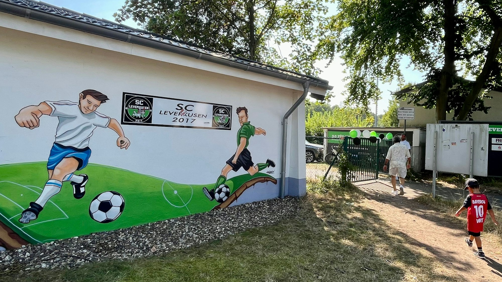 Junge im Florian-Wirtz-Trikot geht auf den Fußballplatz des SC Leverkusen.