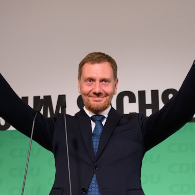 01.09.2024, Sachsen, Dresden: Michael Kretschmer (CDU), amtierender Ministerpräsident von Sachsen und Spitzenkandidat, winkt nach der Verkündung der ersten Hochrechnungen auf der Bühne. In Sachsen fand am Sonntag die Landtagswahl statt. (zu dpa: «Alles ausgezählt: CDU wird in Sachsen stärkste Kraft») Foto: Robert Michael/dpa +++ dpa-Bildfunk +++