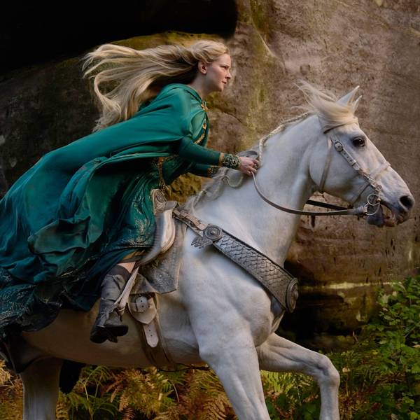 Die walisische Schauspielerin Morfydd Clark reitet in ihrer Rolle als Elbenkriegerin Galadriel in der Amazon-Prime-Video-Serie „Der Herr der Ringe: Die Ringe der Macht“ einen Schimmel. Ihre blonden Haare und ihre grünen Gewänder wehen im Wind.