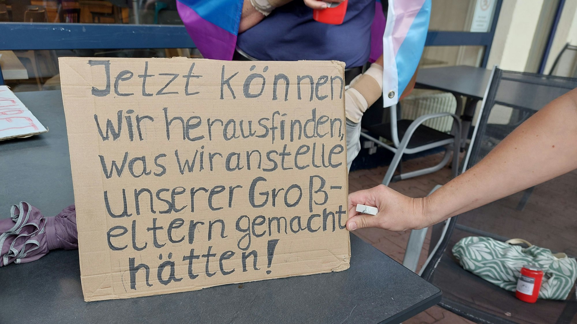 Eine Hand schält ein Pappschild.