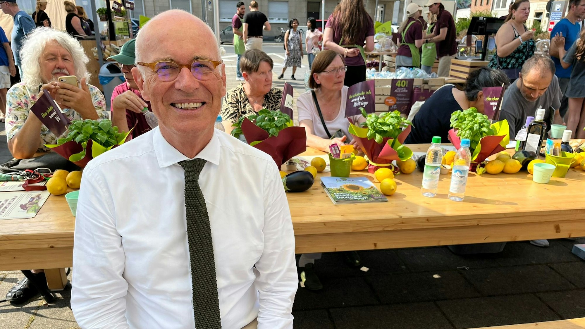 Götz Rehn sitzt mit Kunden an einem Tisch.