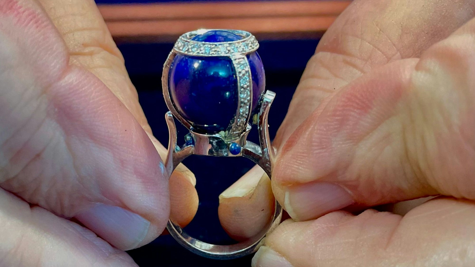 Ring mit Kugelstein, der mit Diamanten besetzt ist.