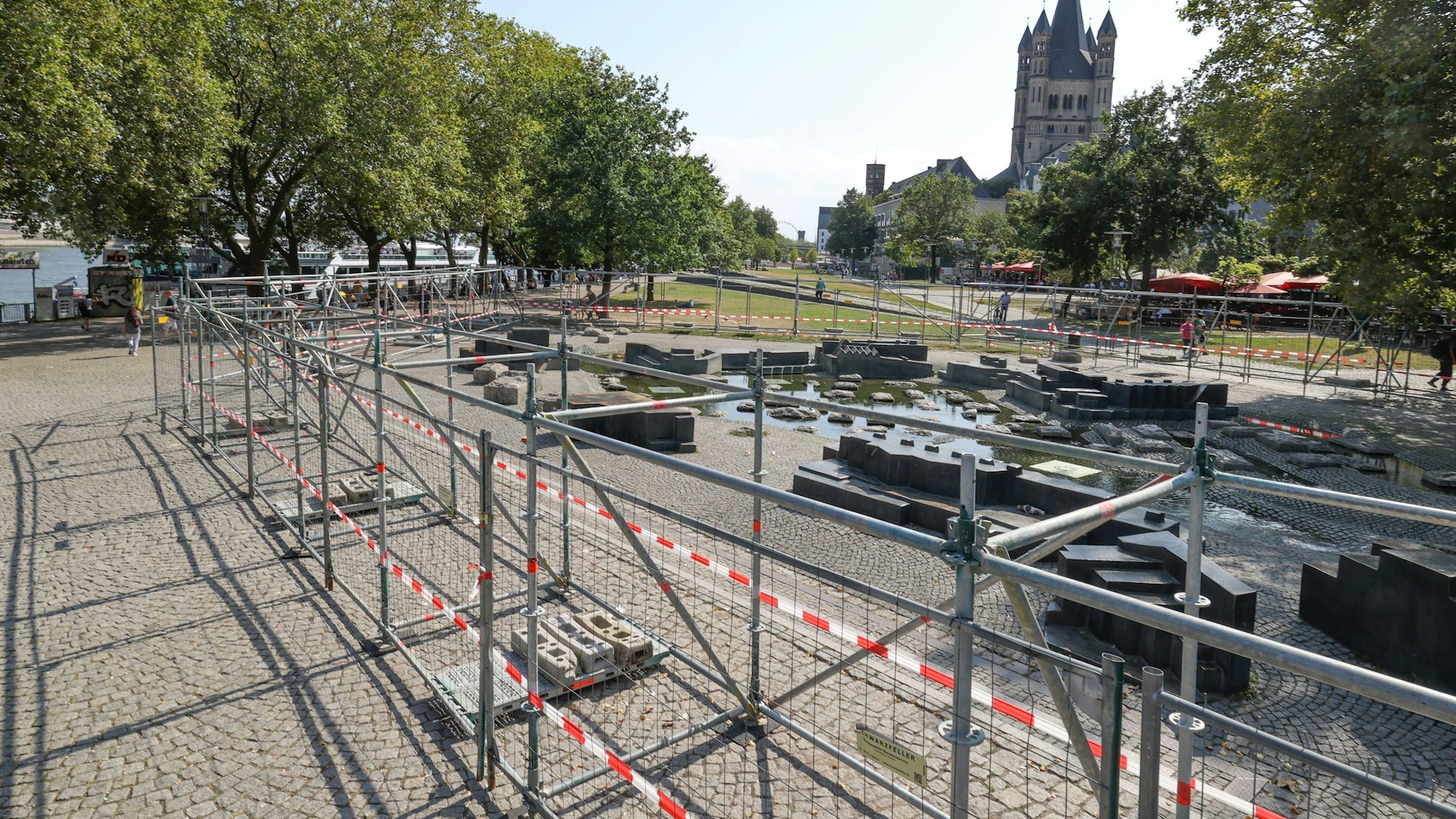 Große Sperrgitter umzäunen den Paolozzibrunnen im Rheingarten