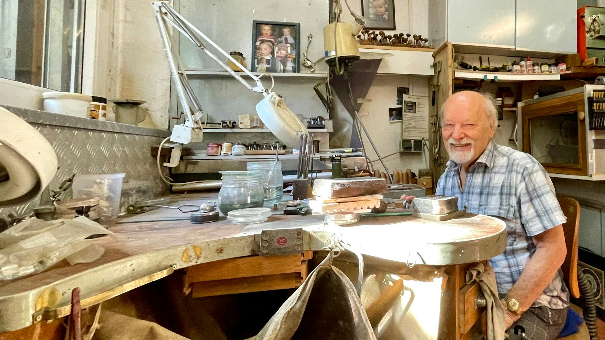 Goldschmied Herbert Schmelzer sitzt an seinem Arbeitsplatz.