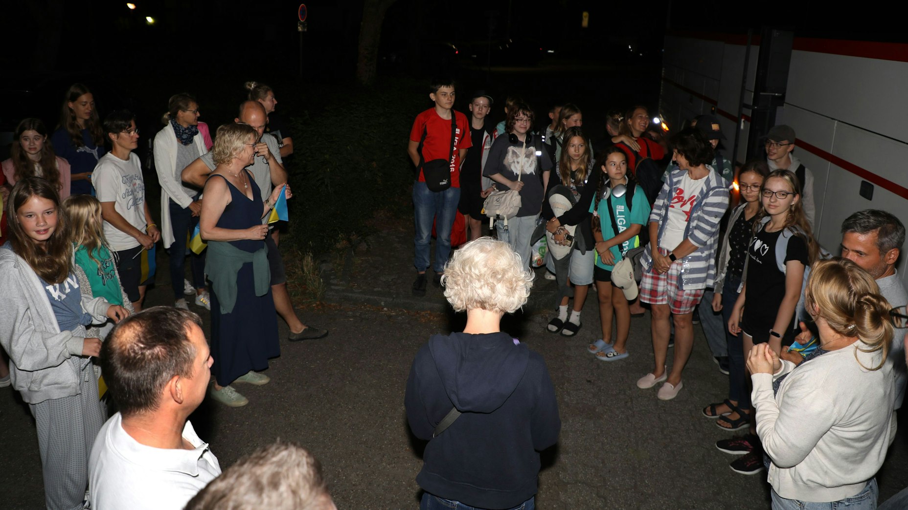Zwei Gruppen von Kindern und Erwachsenen stehen sich gegenüber.