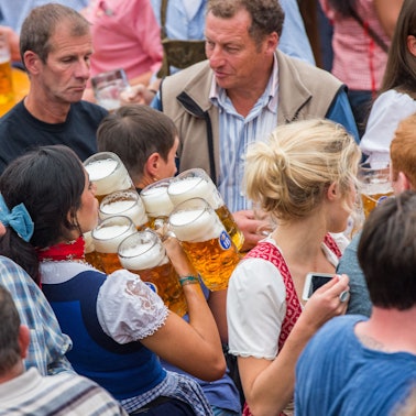 Eine Kellnerin trägt auf dem Münchner Oktoberfest auf der Theresienwiese in München (Bayern) im Hofbräuzelt zehn Maß Bier zu einem Tisch.