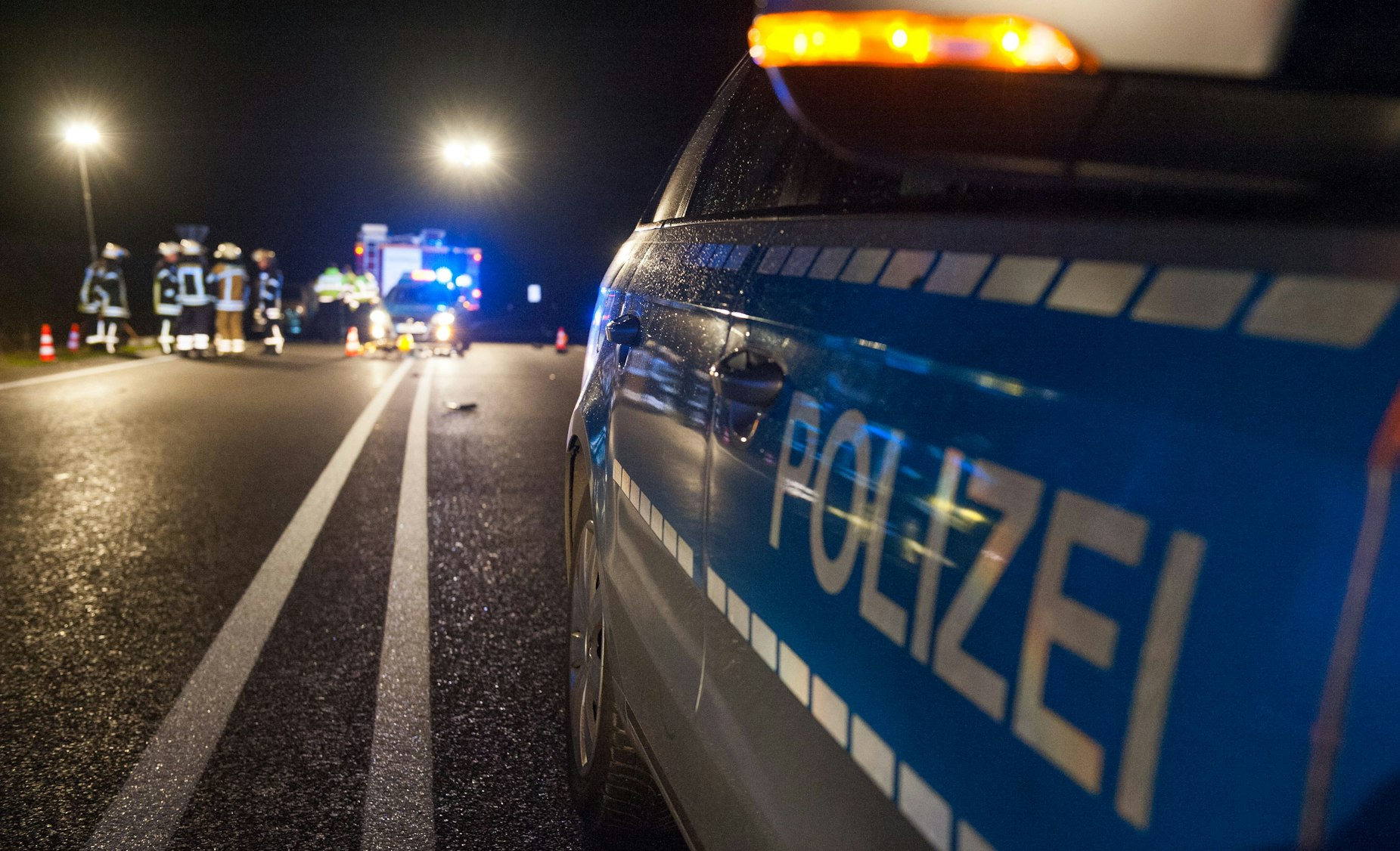 German police at a night emergency scene, investigating a burglary.