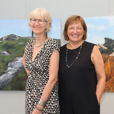 Inge Maxeiner und Annemarie Busse stehen bei einer Vernissage nebeneinander.