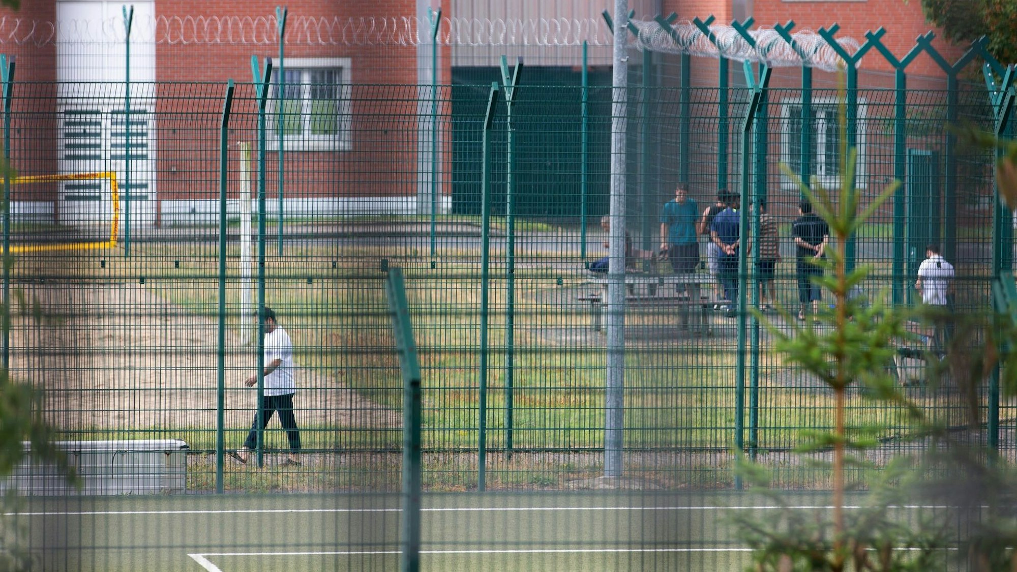 Insassen der Unterbringungseinrichtung für Ausreisepflichtige (UfA) der Bezirksregierung Detmold stehen auf dem Freigelände beieinander.