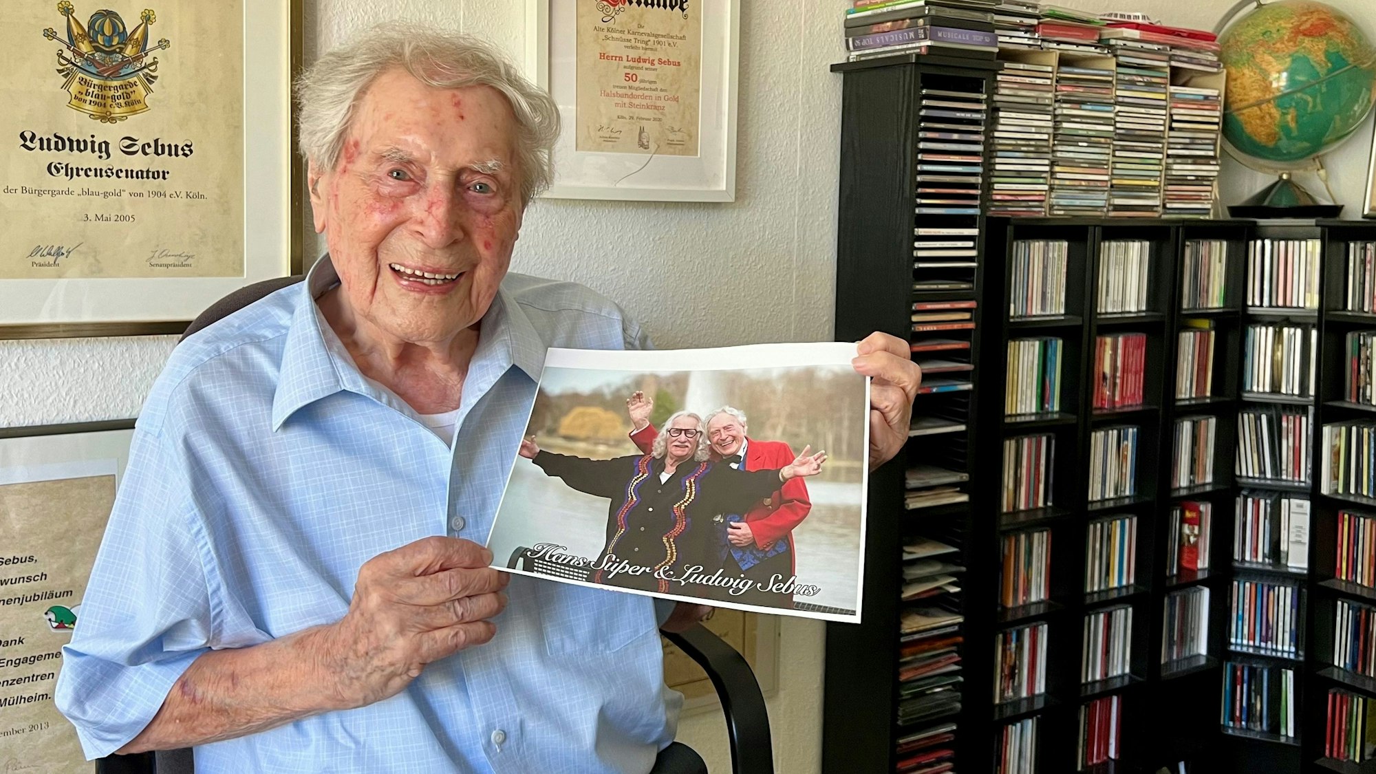 Ludwig Sebus zeigt in seinem Arbeitszimmer ein Foto von sich und seinem verstorbenen Kollegen und Freund Hans Süper