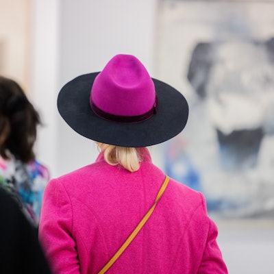 Besucher der Art Cologne gehen durch eine Messehalle der Kunstmesse Art Cologne.