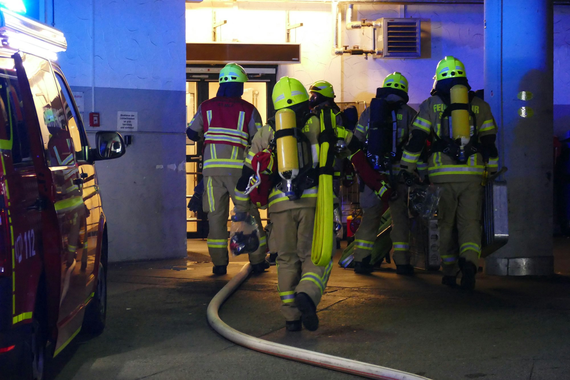 Feuerwehrleute vor einem Treppenhaus.