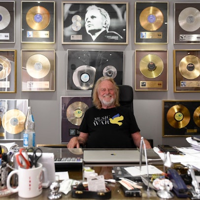 Zu sehen ist Dieter Dierks vor vielen goldenen Schallplatten.