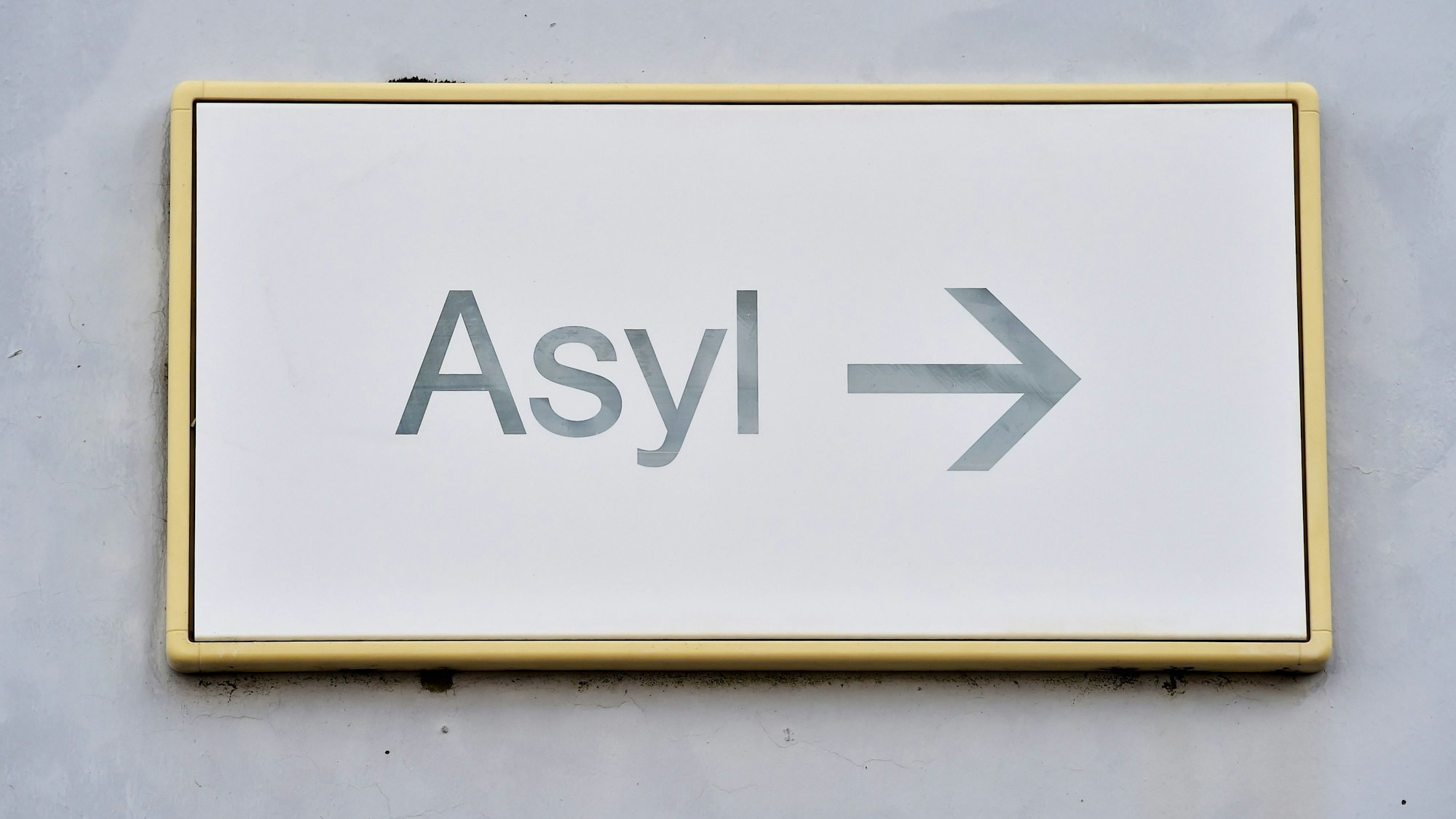 Ein Schild mit der Aufschrift „Asyl“ hängt in einer Erstaufnahmestelle für Asylbewerber an einer Wand. (Archivbild)