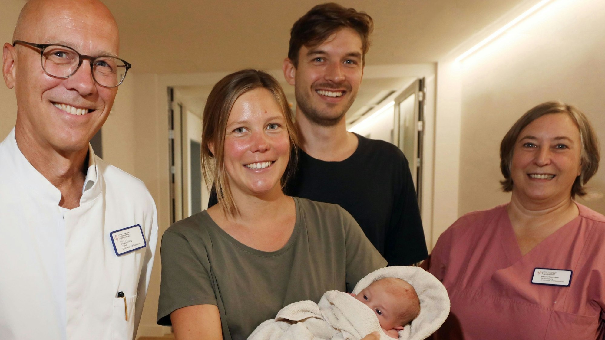 Zu sehen sind Der Chefarzt der Gynäkologie und Geburtenhilfe Prof. Dr. med. Jan Schmolling und Hebamme Marzena Koprowski mit den stolzen Eltern Debora, die ihren Sohn Oskar auf dem Arm trägt, und Christian Pfeil.
