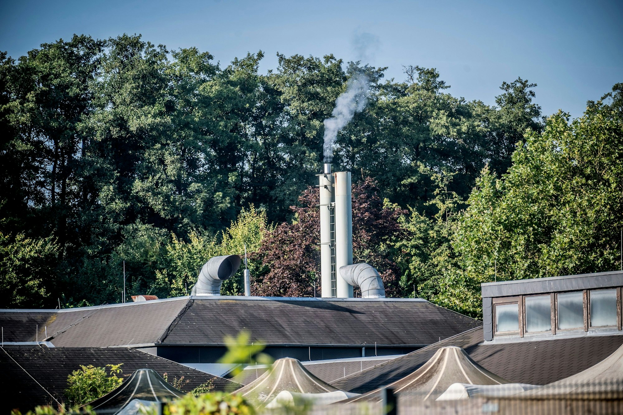 Der Kamin des Blockheizkraftwerks raucht.