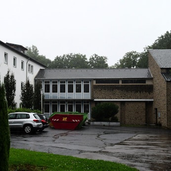 Außenansicht der früheren Apostolischen Schule in Bad Münstereifel. Container stehen vor dem Gebäude.