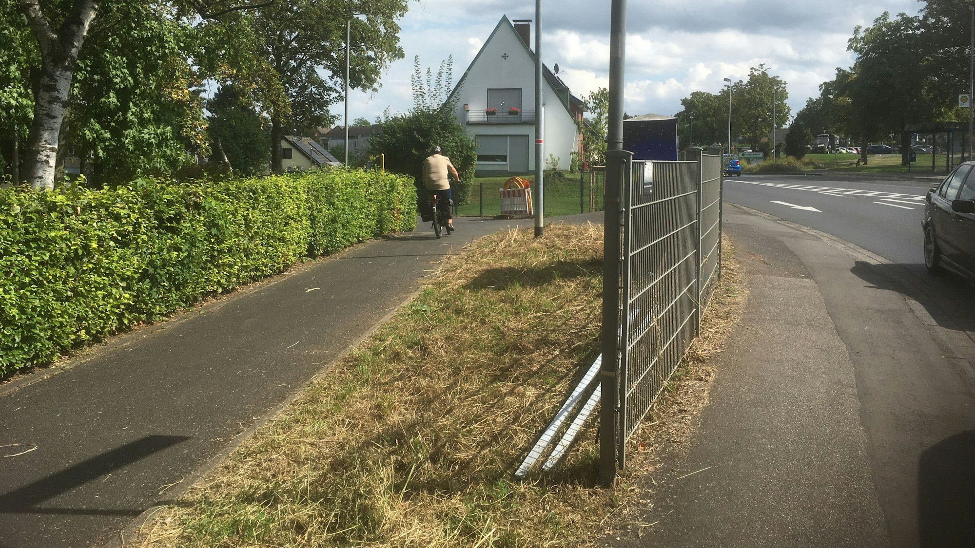 Ein Radweg mündet an einem Zaun im spitzen Winkel in die Bonner Straße.
