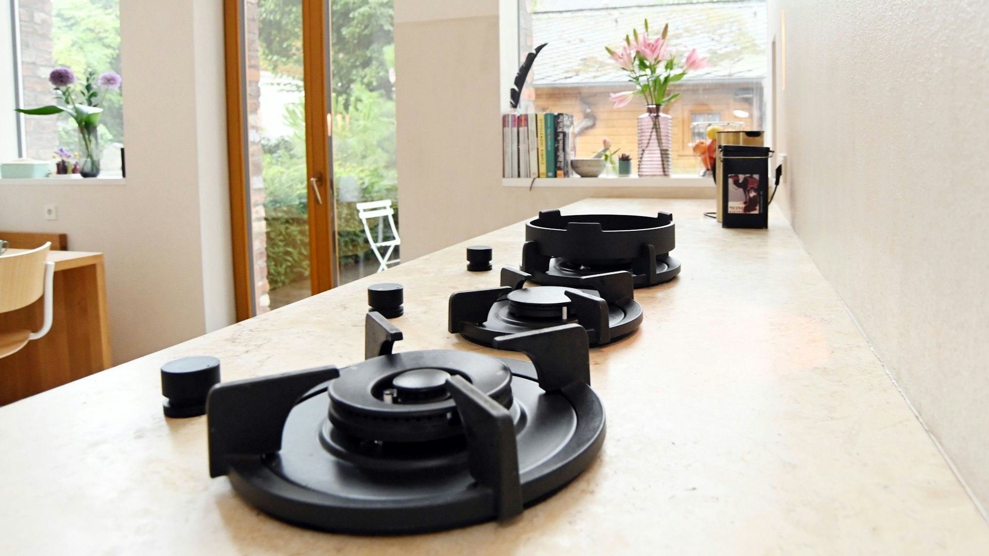 Zu sehen ist eine Küche. Im Hintergrund geht es zum Garten raus.