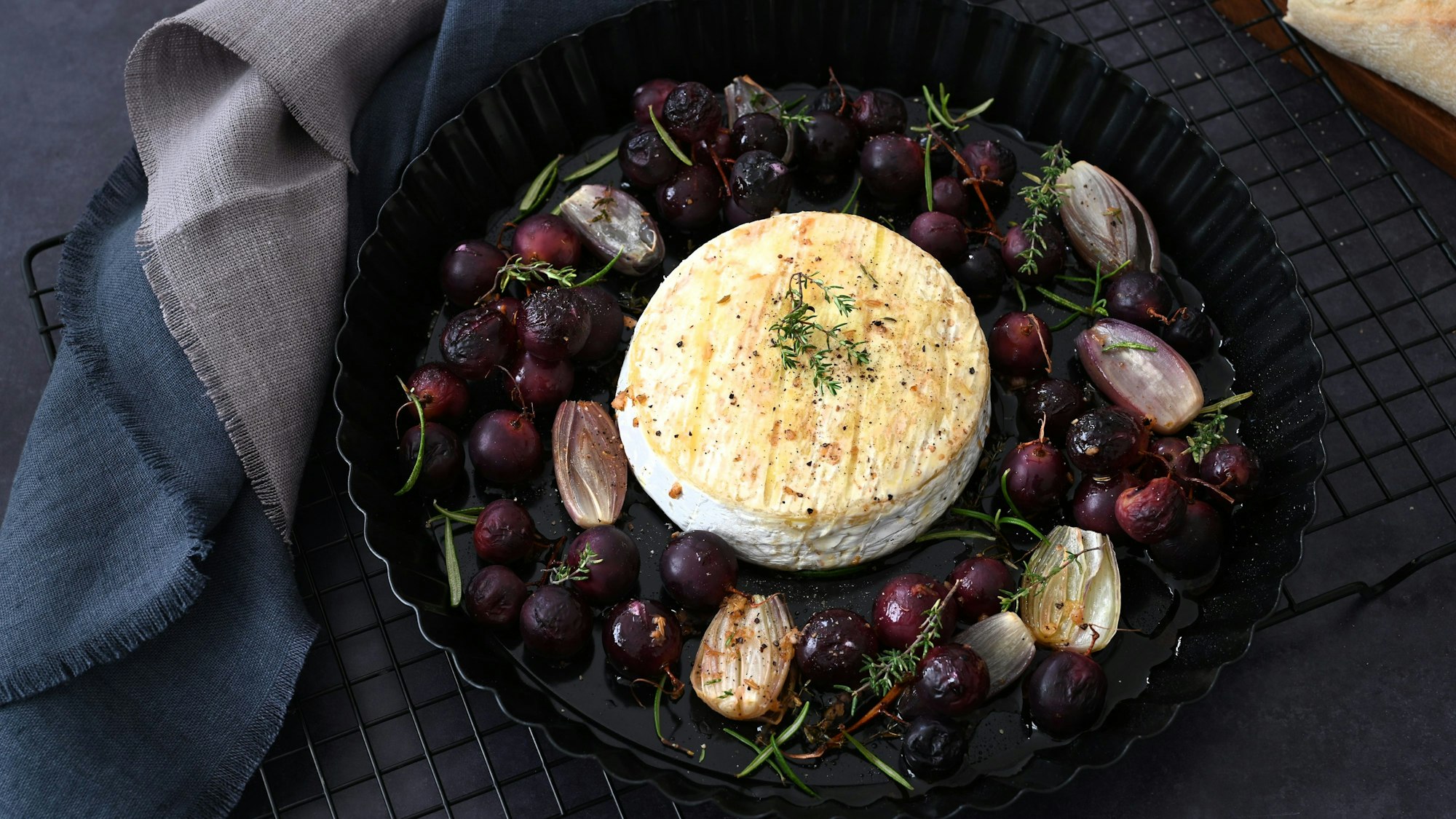 Der Camembert kommt in die Mitte, Schalotten und Tafeltrauben drumherum.