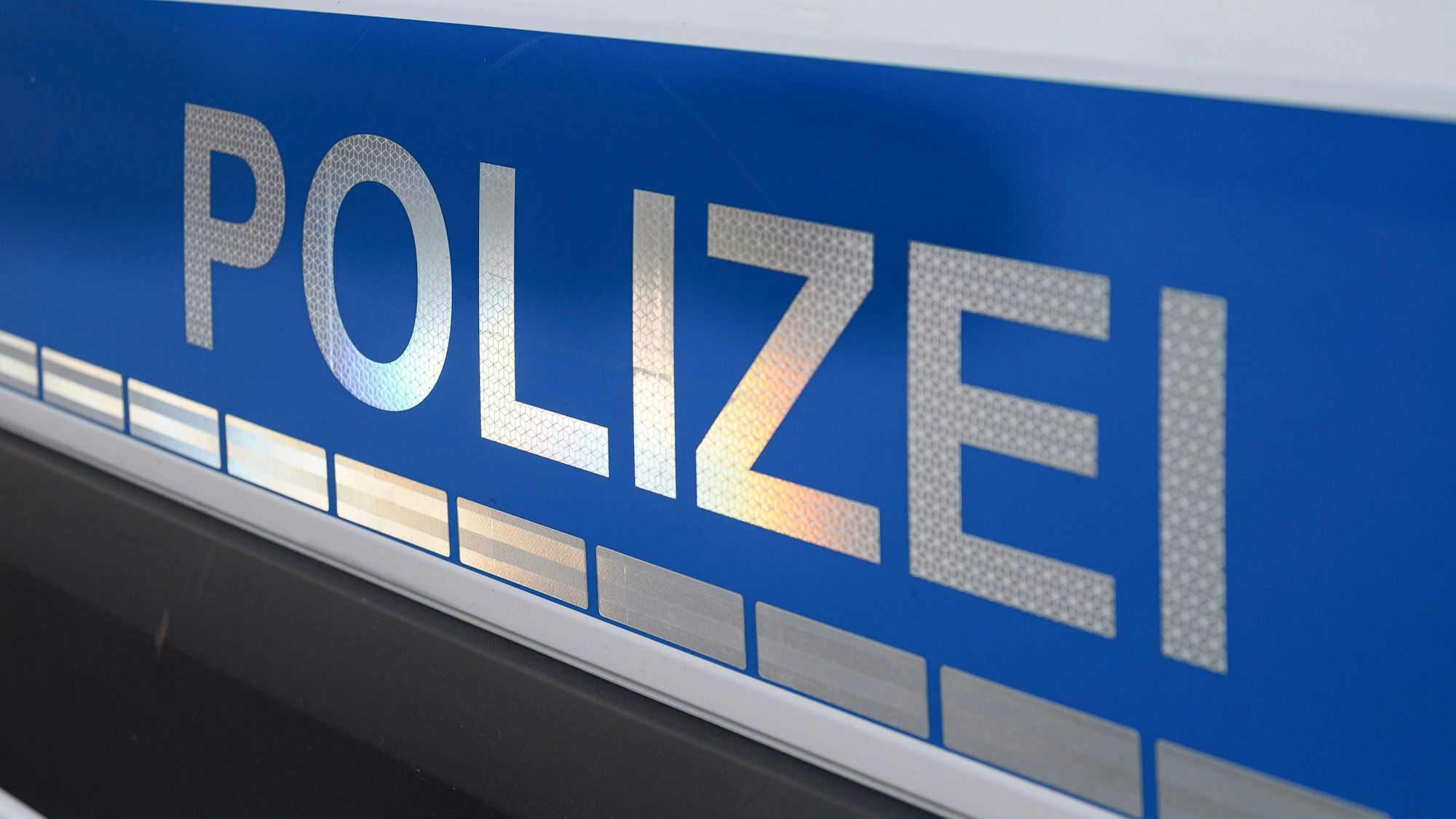 Der Polizei-Schriftzug auf einem Einsatzwagen.