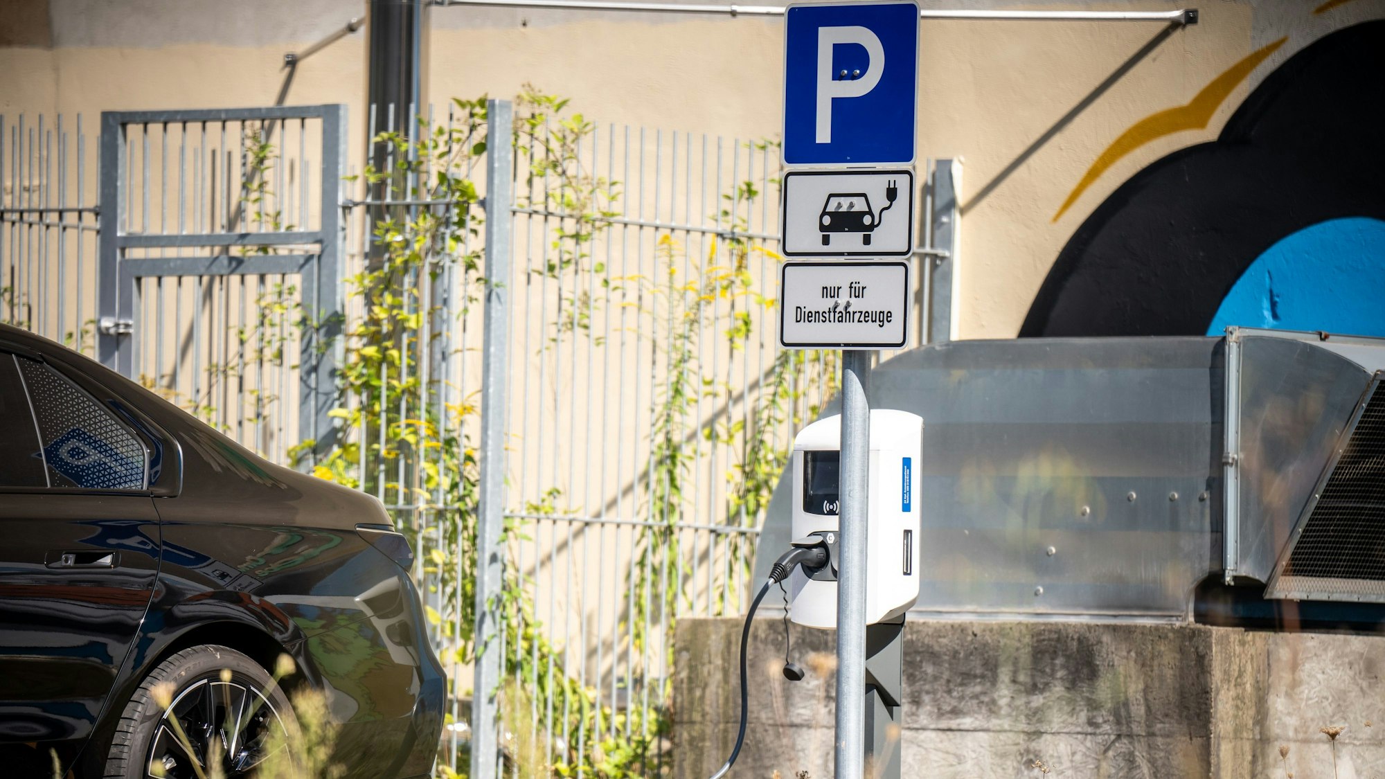 Ein Elektro-Fahrzeug parkt an einer Wallbox auf einem Parkplatz für Dienstwagen auf einer Brache in Berlin-Mitte.