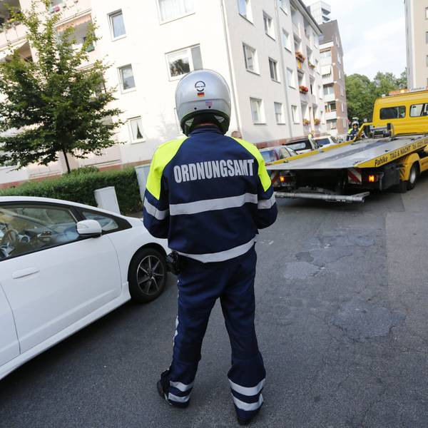 Das Foto zeigt eine Person mit der Aufschrift „Ordnungsamt“ auf der Jacke vor einem Abschleppwagen.