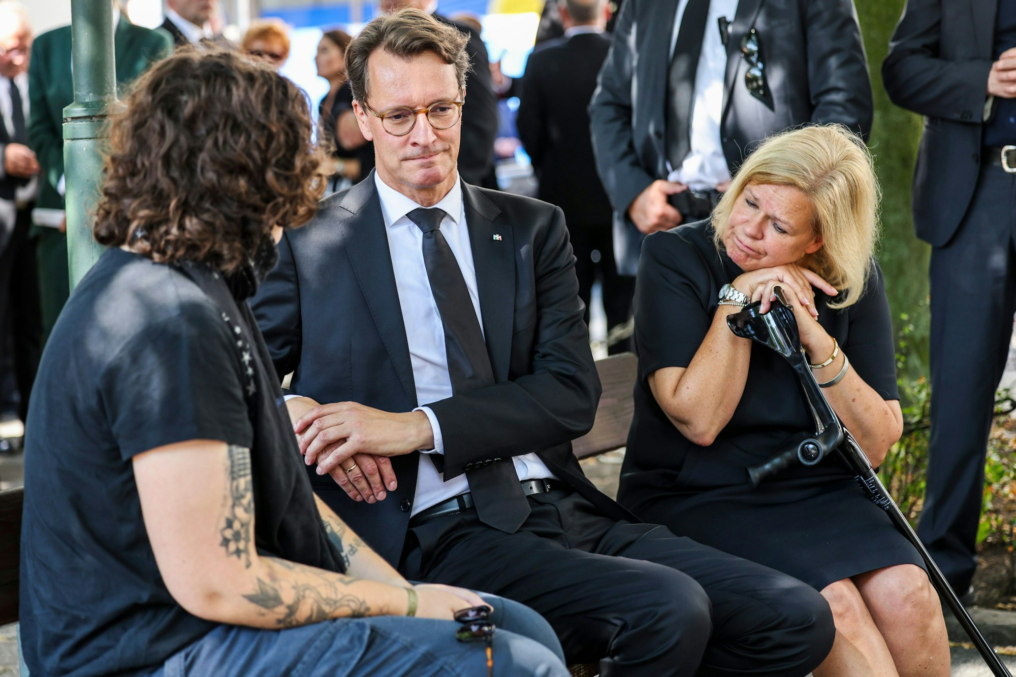 Hendrik Wüst (CDU, M), Ministerpräsident des Landes Nordrhein-Westfalen, und Bundesinneministerin Nacy Faeser (SPD, r) im Gespräch mit einer Angehörigen vor der Kranzniederlegung am Fronhof in Gedenken an die Opfer der Messerattacke auf dem Solinger Stadtfest.