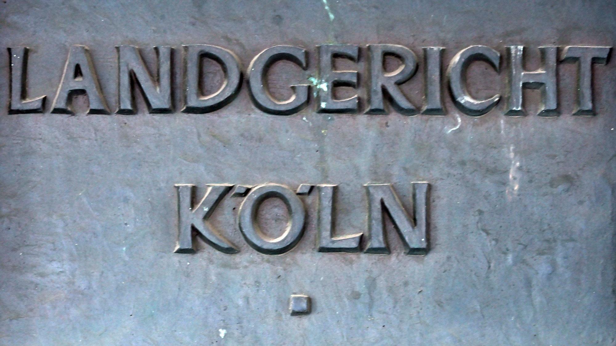 Ein Schild weist auf das Landgericht in Köln hin.