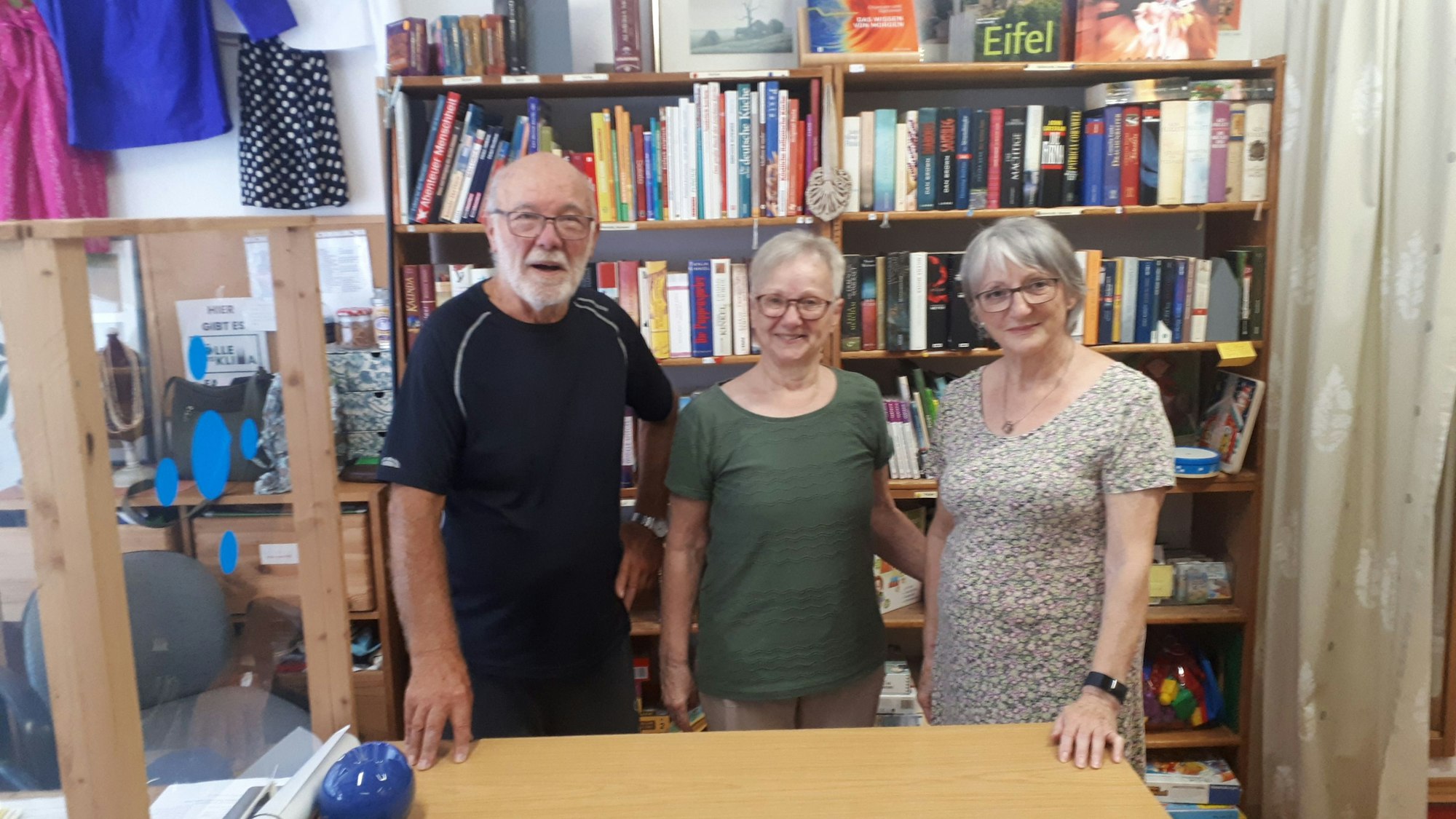 Zu sehen sind Rolf Eischeid (l.) hinter der Theke mit zwei weiteren Ehrenamtlerinnen.