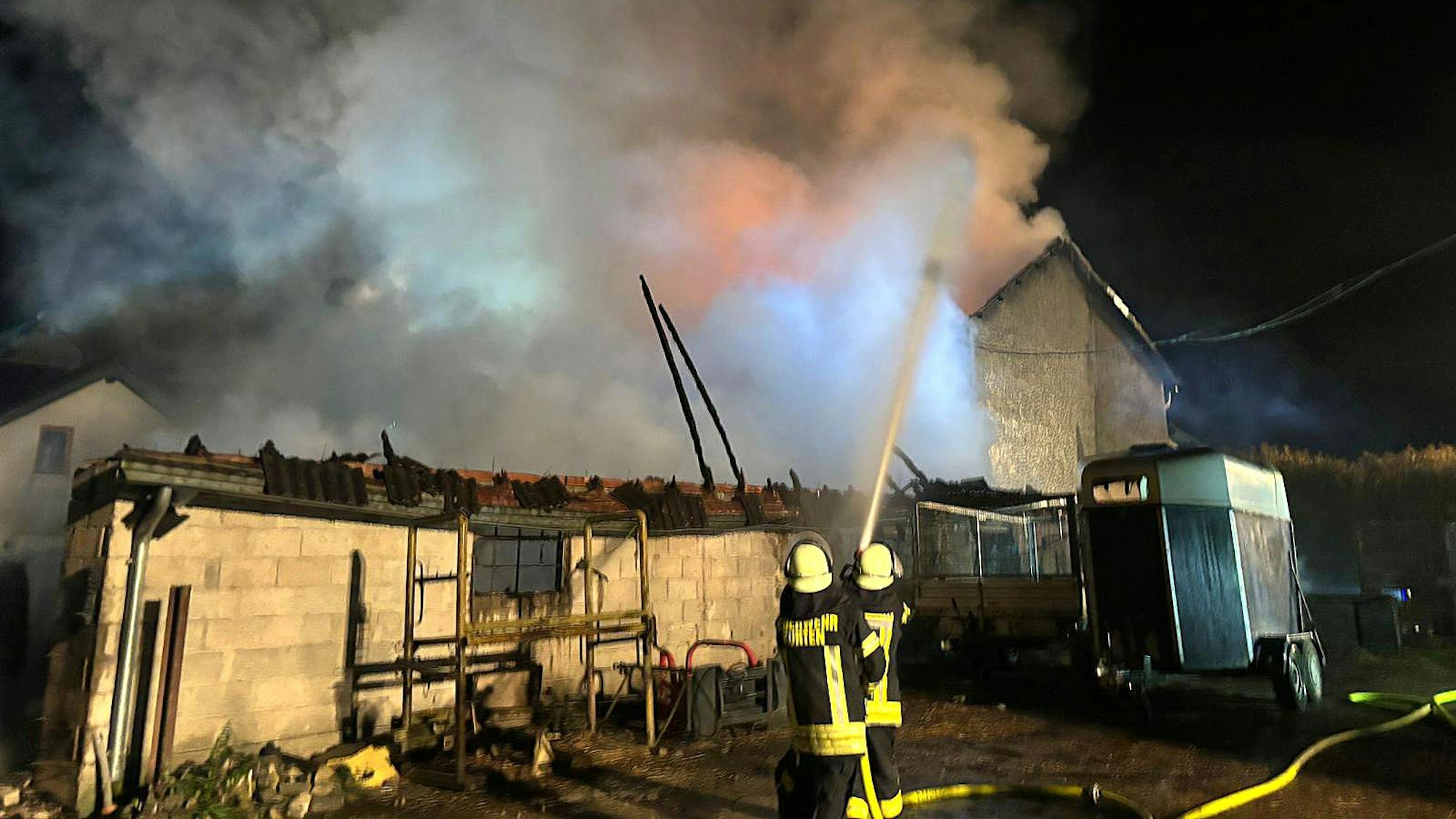 Feuerwehrleute löschen ein Wirtschaftsgebäude eines Bauernhofs bei Kürten-Dürscheid.