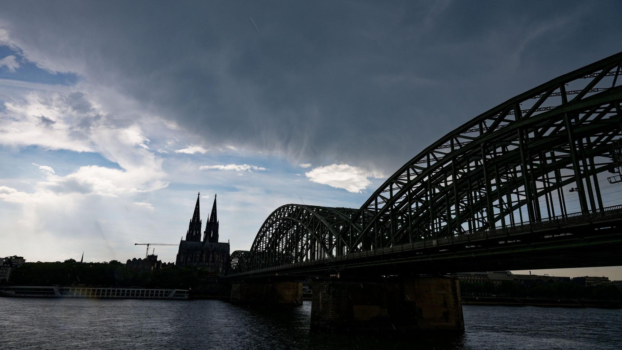 Eine dunkle Gewitterwolke zieht über dem Dom in Köln auf.