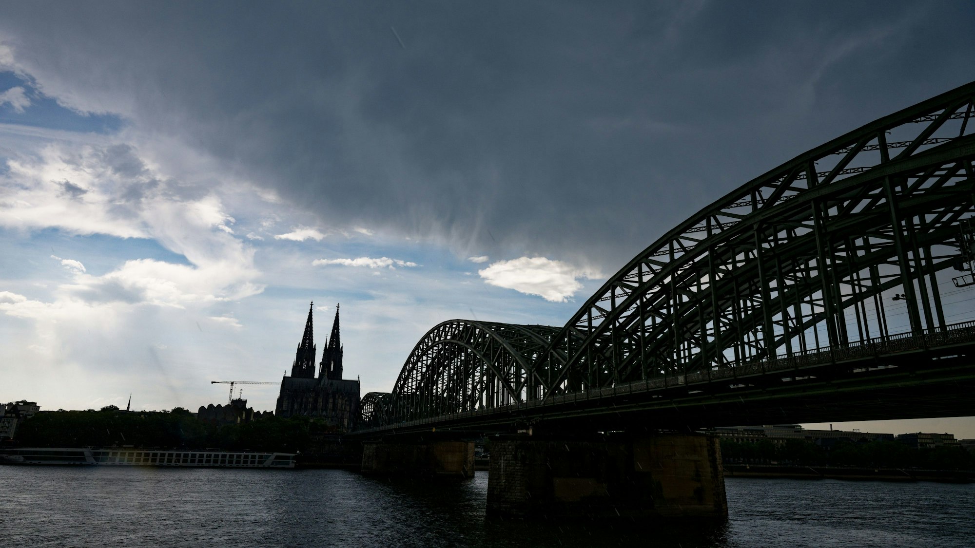 Eine dunkle Gewitterwolke zieht über dem Dom in Köln auf.