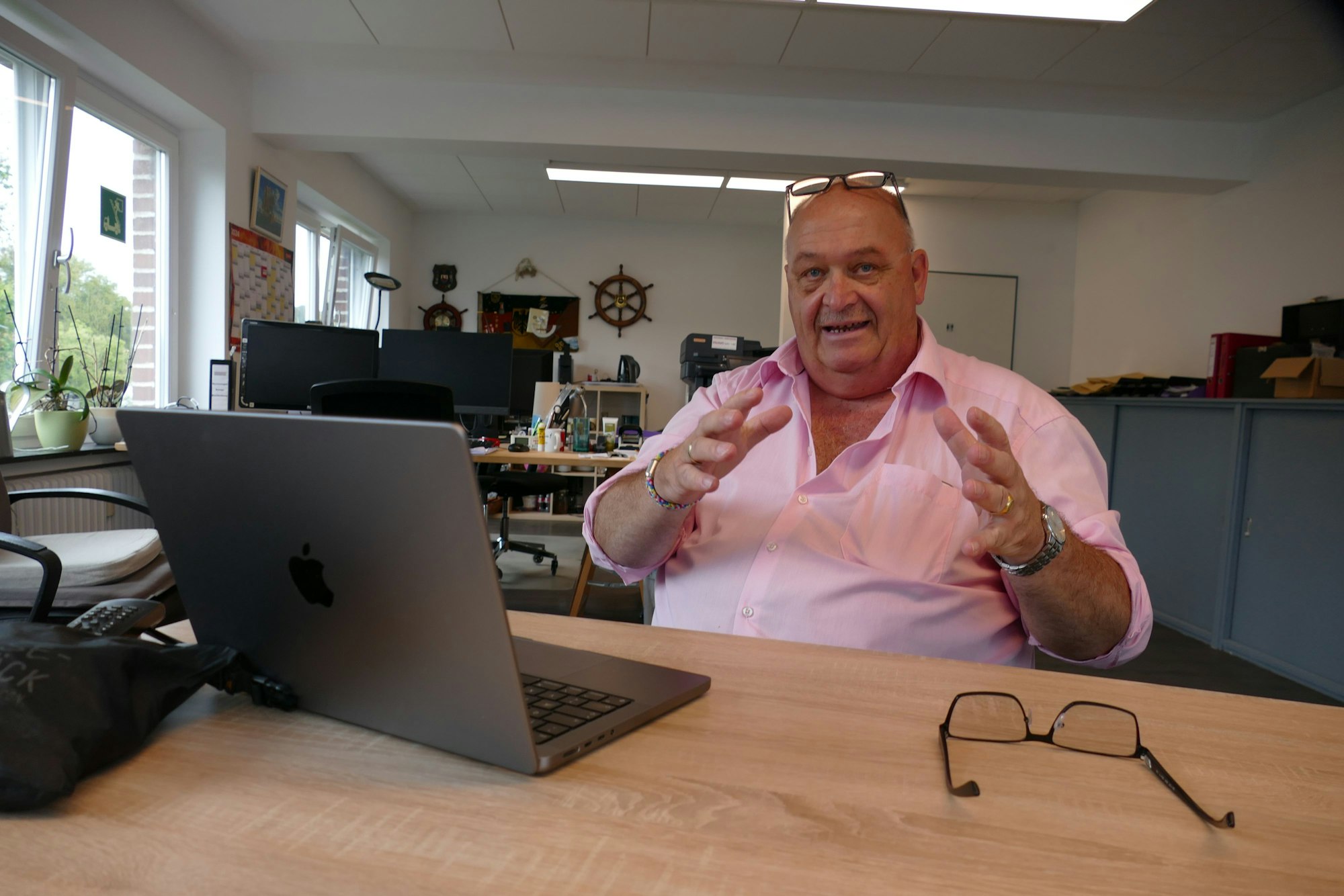 Ein Mann sitzt an einem Tisch vor einem Laptop.