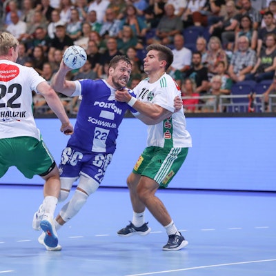 Handballer Kentin Mahé setzt sich im Angriffsspiel zwischen zwei gegnerische Spieler aus Hannover durch.