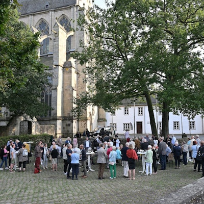 Viele Menschen stehen auf dem Platz vor dem Altenberger Dom und feiern, dass die Fläche nun "Maria-Zanders-Platz" heißt.