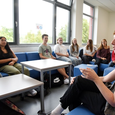Das Foto zeigt Jana Goller im Gespräch mit Schülerinnen und Schülern des EvB-Gymnasiums Wipperfürth.