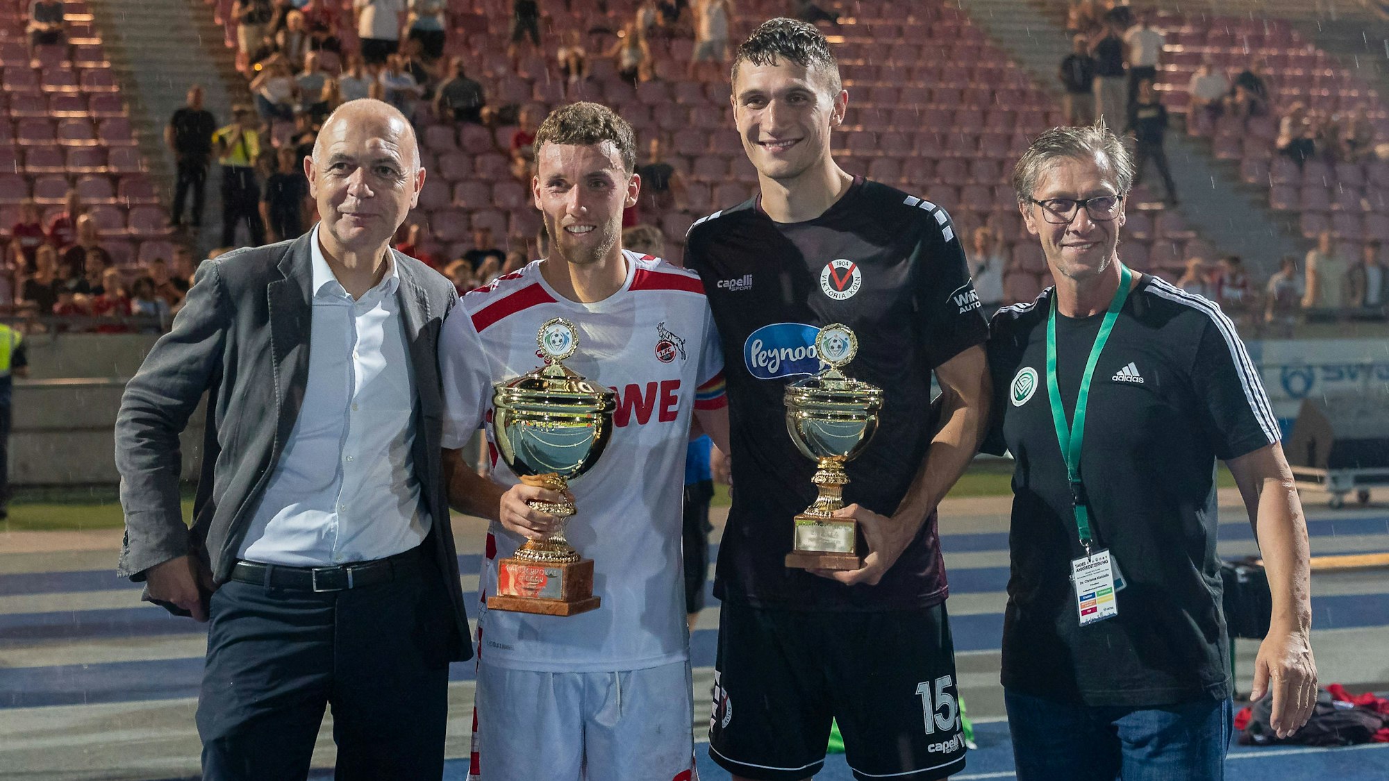 DFB-Präsident Bernd Neuendorf mit FC-Kapitän Luca Waldschmidt, Viktorias Spielführer Christoph Greger und FVM-Chef Christos Katzidis bei der Siegerehrung (v.l.)