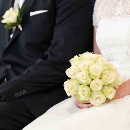 Ein Brautpaar sitzt während ihrer Trauung in der Kirche.